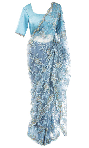 Pre-pleated lacy net saree, paired with  blue silk top is studded with diamonds.