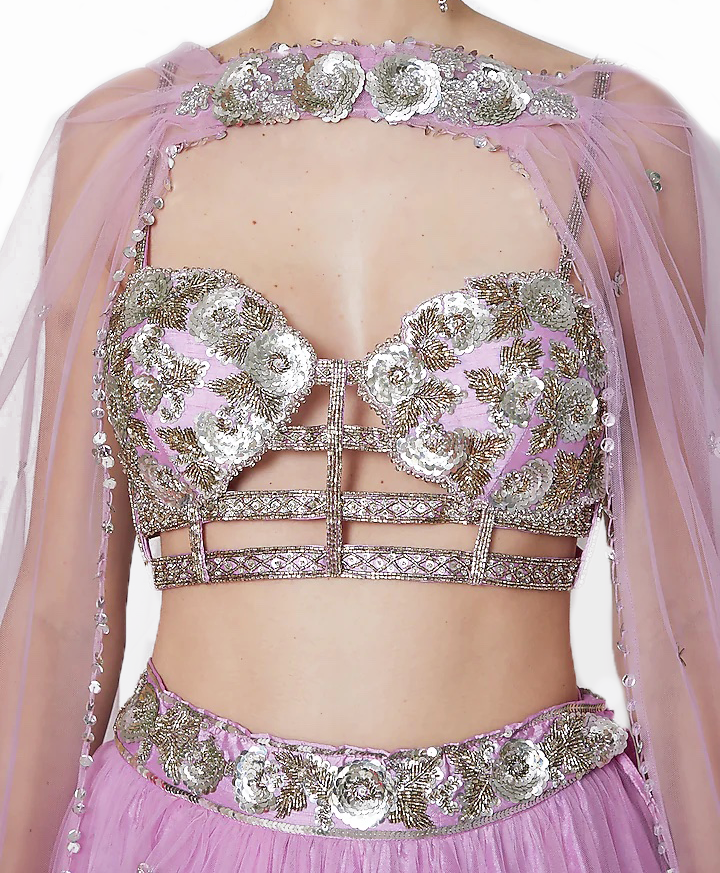 The lehenga is embroidered with silver sequins on a dupioni foundation. It is paired with a blouse that matches it.