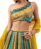 Green lehenga it is paired with a matching blouse having asymmetrical neckline and a soft net dupatta.