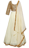 The lehenga skirt is crème in color, and the long-sleeve blouse is completely covered in gold sequins.