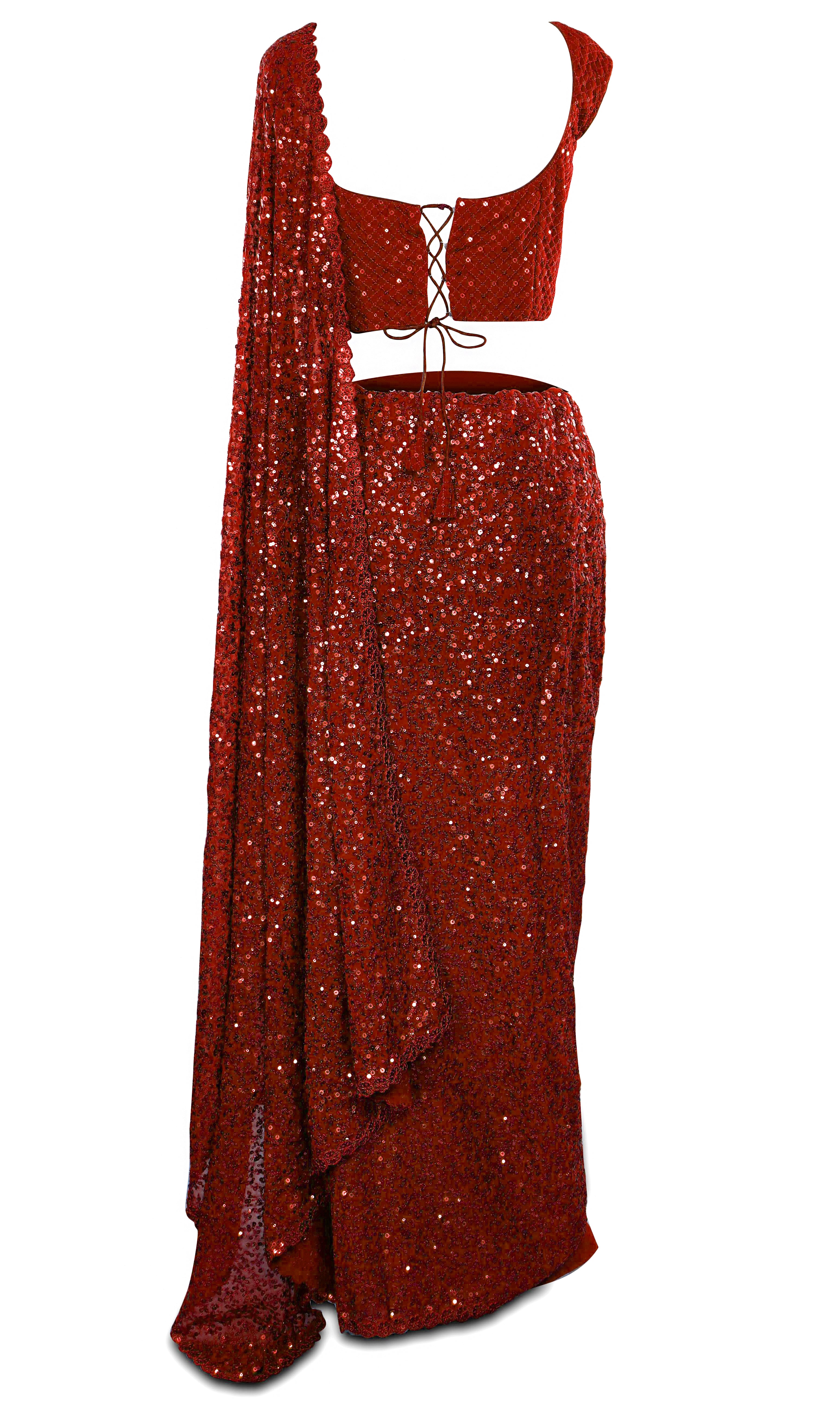 Saree is ready-made and pre-pleated paired with a sequined sleeveless blouse.