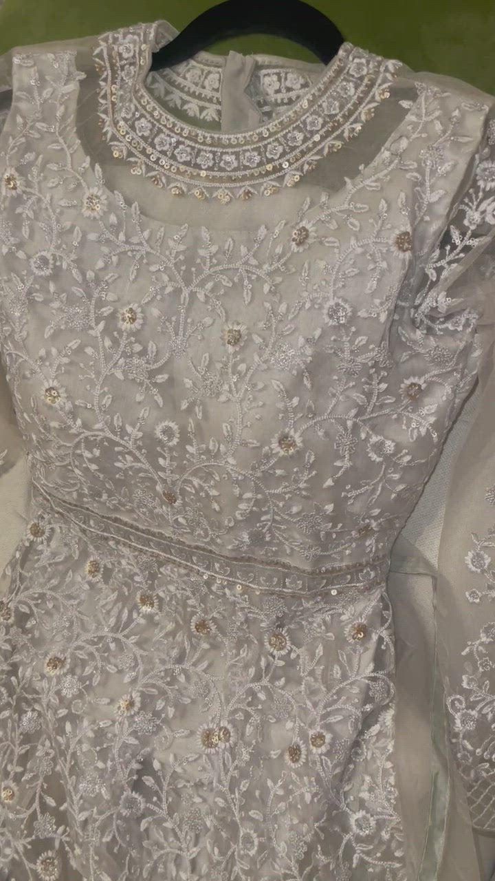 Silver/white Anarkali suit decorated with gold sequins & includes matching bottom and white net dupatta