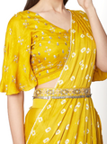 Yellow pre-stitched saree by Ruchira Nangalia paired with a matching boho belt